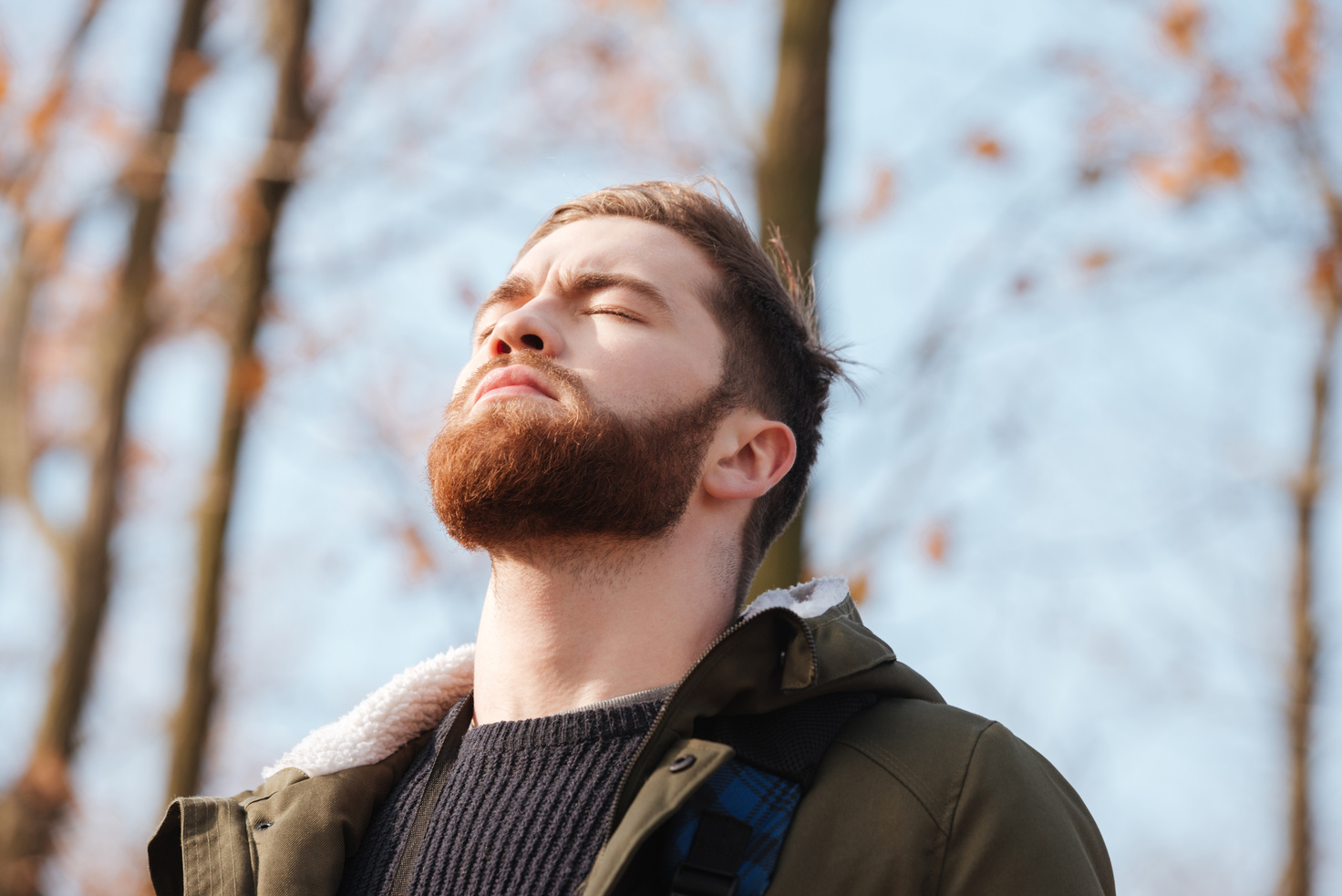 Relaxed Bearded Man Standing in the Forest with Eyes Closed