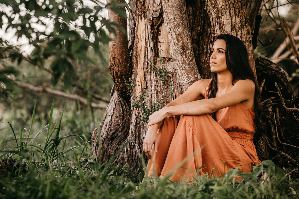 Contemplative ethnic woman admiring nature in countryside